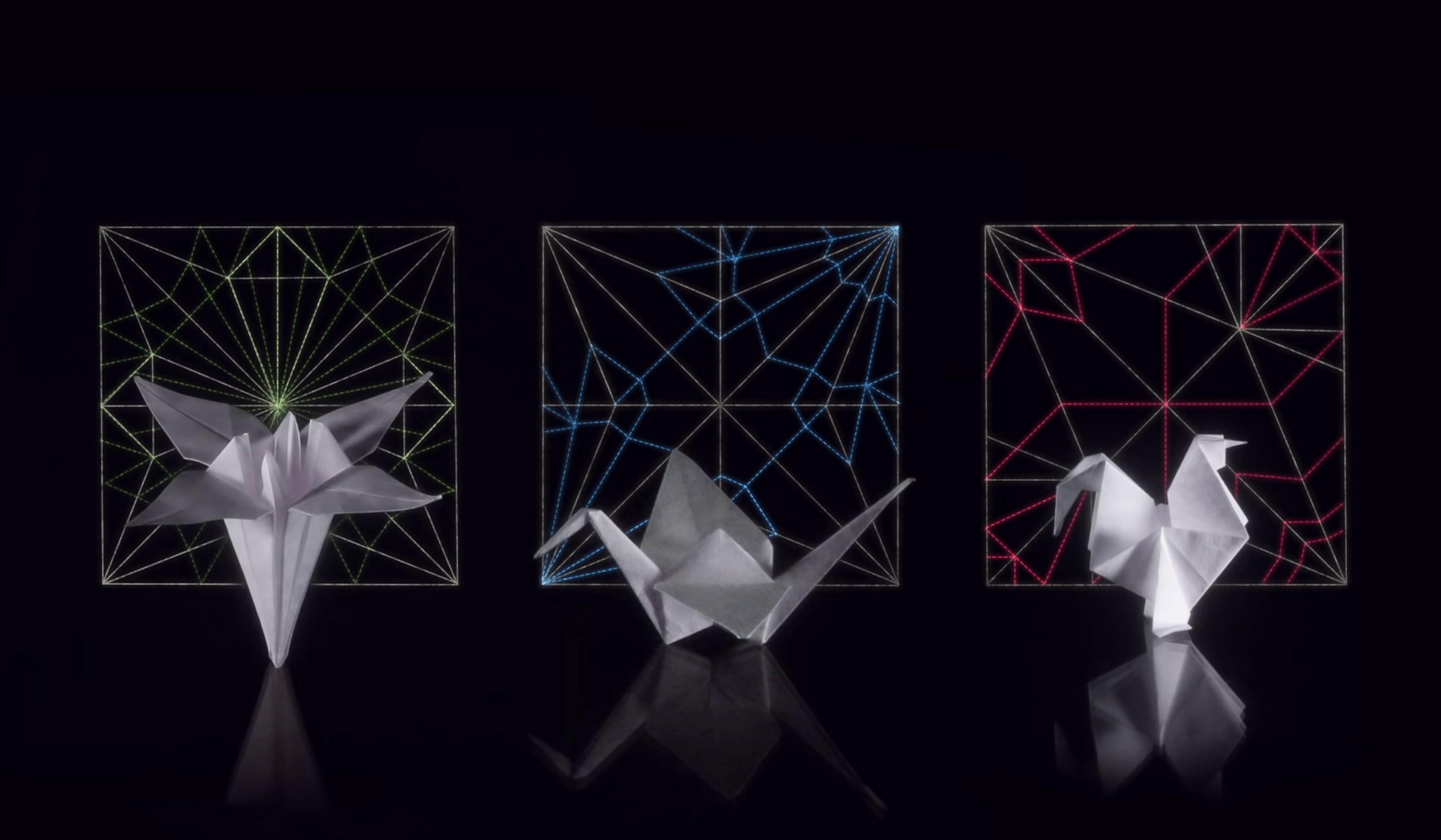 Three origami figures in front of geometric light patterns on a black background, featuring a flower, a crane, and a rooster.