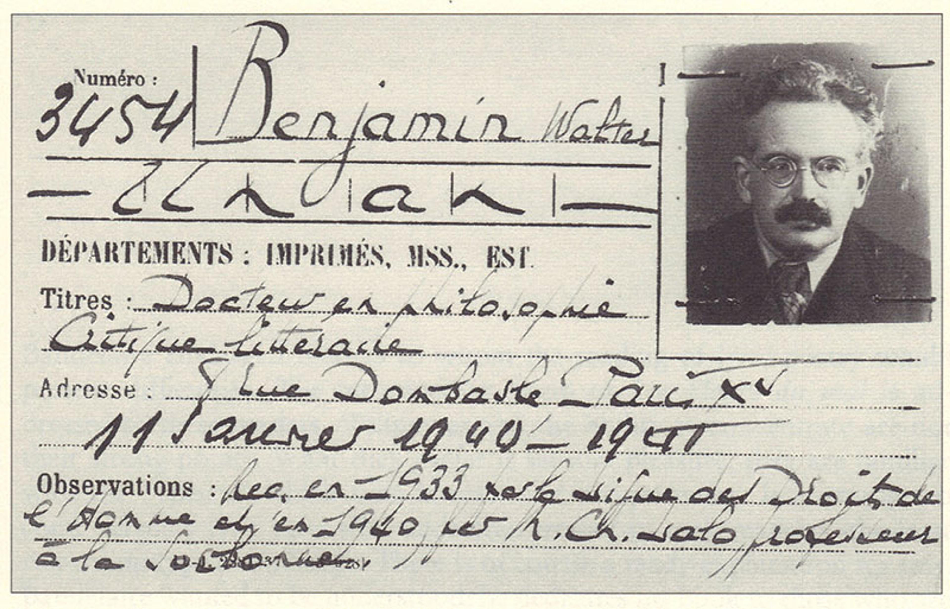 Black-and-white photo of Walter Benjamin’s library card featuring handwritten text and portrait photo of him, a middle-aged man with a moustache and glasses.